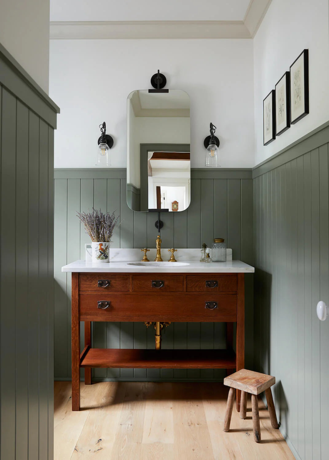 Cold Brook Farm powder room with sage green wainscoting, vintage wood vanity with marble top, brass faucet, and farmhouse-inspired details.