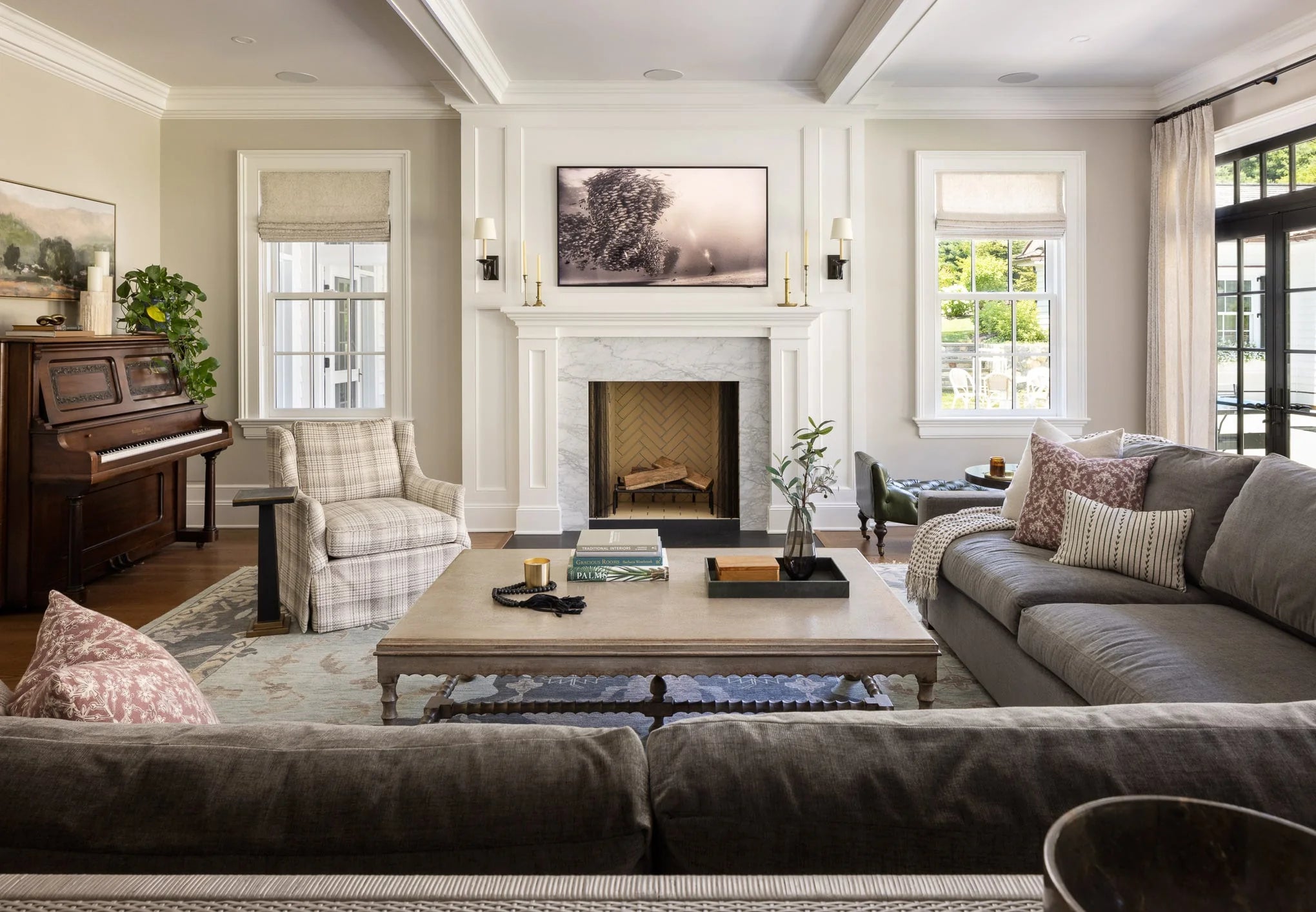 Elegant living room with white marble fireplace, gray sofas, and natural light from tall windows at Moonlight project.